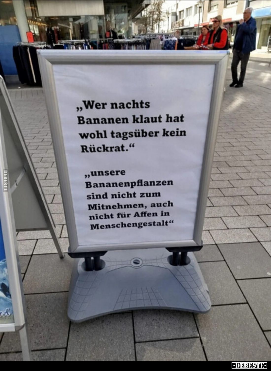 Der Text auf der Tafel lautet: „Wer nachts Bananen klaut hat wohl tagsüber kein Rückrat.“ und „unsere Bananenpflanzen sind ni...